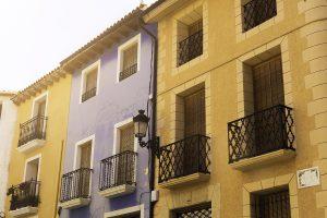 Vintage lantern and beautiful twisted wrought iron balconies on the facade of an old house of a European city.