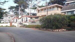 Typical suburban street, residential district, detached houses or single-family homes, road in Carmel city, Monterey, California generic architecture, USA. Neighborhood real estate property in suburb.