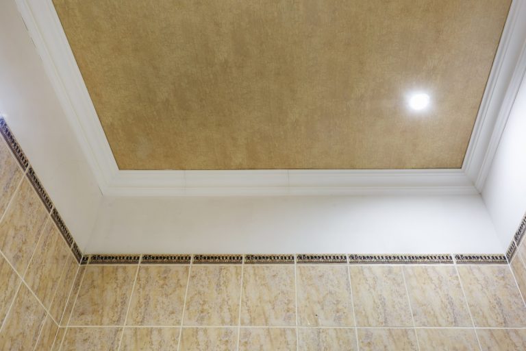 Detail of corner ceiling with intricate crown molding. Suspended ceiling and drywall construction in empty room in apartment or house. Stretch ceiling white and complex shape. Paint For Textured Ceiling.