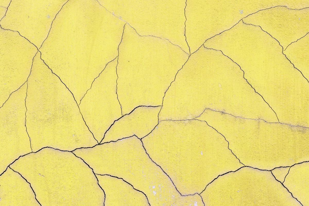 Closeup surface old and crack yellow cement wall texture background. Why Does Concrete Crack.