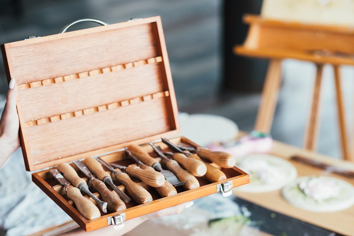 Art craft tools set. Craftsmanship. Carving and modeling. Chisel kit in woman hands. Workroom space. Tools For Clay Sculpting.