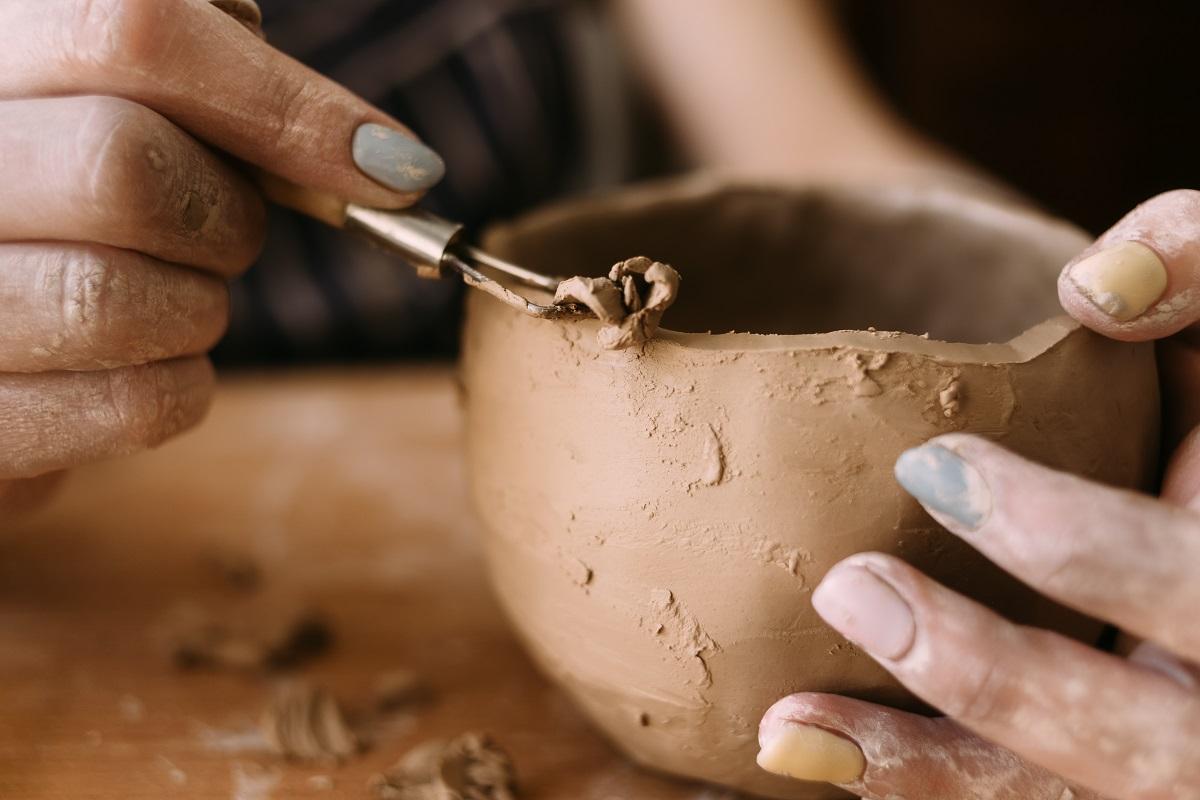 the hands of a clay potter carve a pattern on the bowl. Side view. Ceramics and clay for creativity in the workshop. carving tool, close-up. Things To Remember When Buying Clay Sculpting Tools.