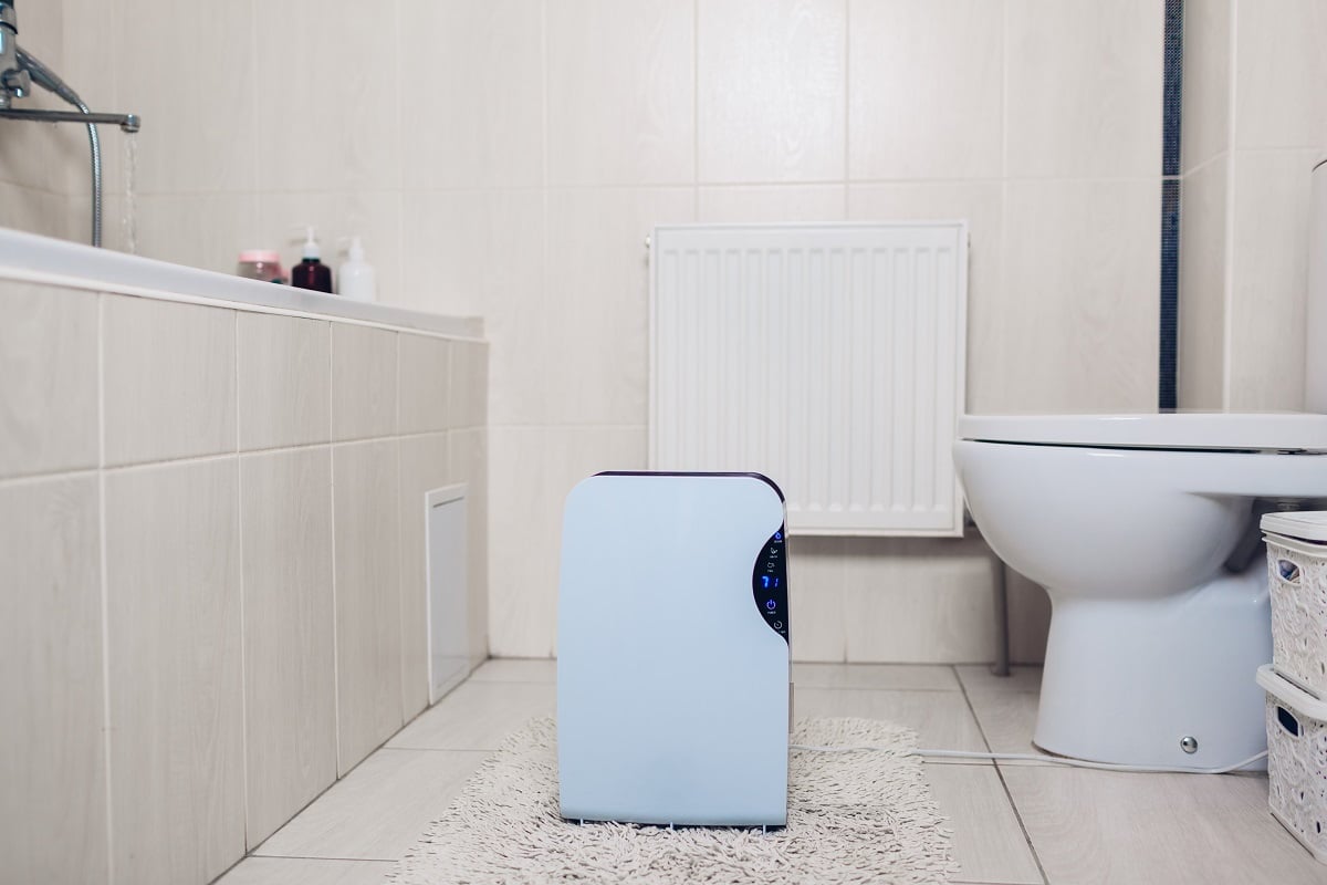 Dehumidifier with touch panel, humidity indicator, uv lamp, air ionizer, water container works at home in bathroom. Air dryer. What Is A Bathroom Dehumidifier.