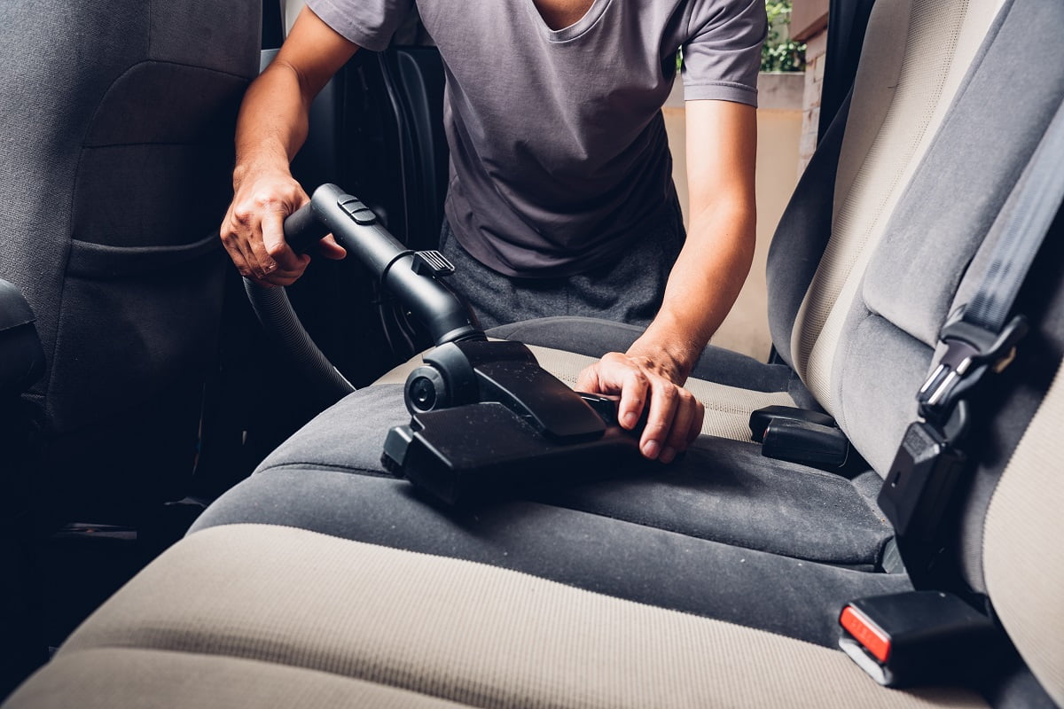 Worker man cleaning dust interior vacuum inside car. How To Clean Car Seat Covers Final Words.