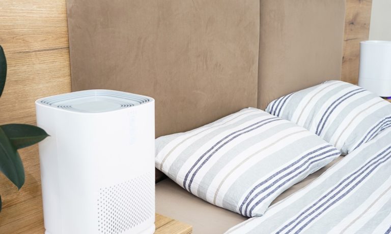 Modern air purifier in the bedroom by the bed. Protect PM 2.5 dust and air pollution concept. Where To Put Dehumidifier In Bedroom.