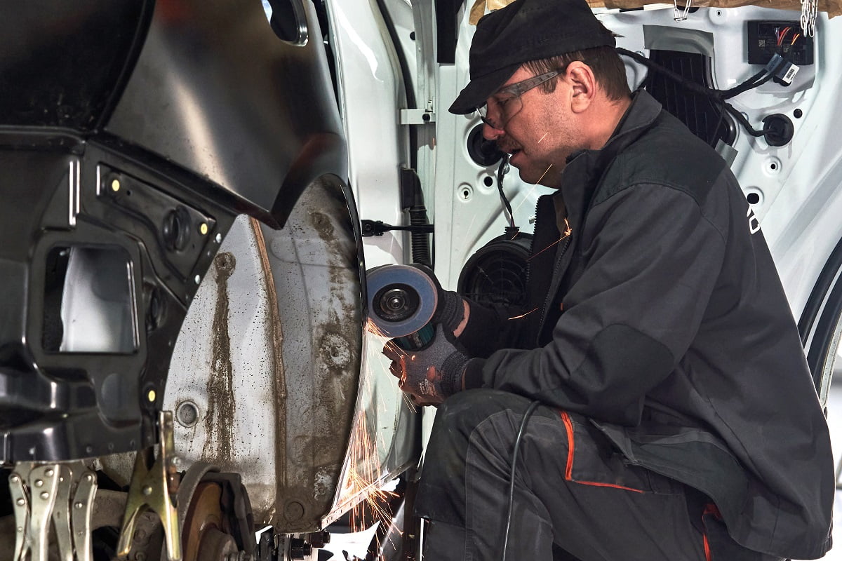 Cutting metal part with sparks in car service station. Angle Grinder To Buff Car Final Words.