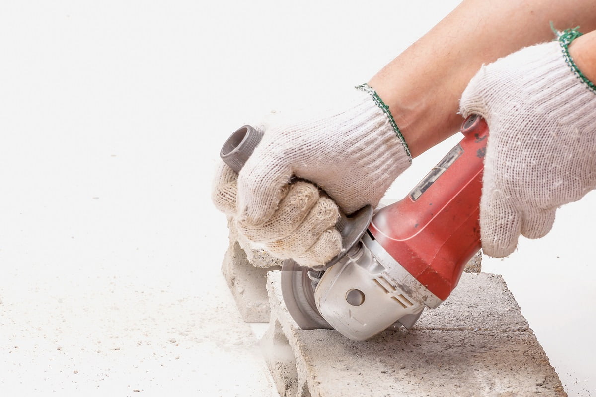 Worker is using angle grinder for cutting cement block, hand tool, focus at blade and isolated over white. Angle Grinder Blade For Concrete Conclusion.