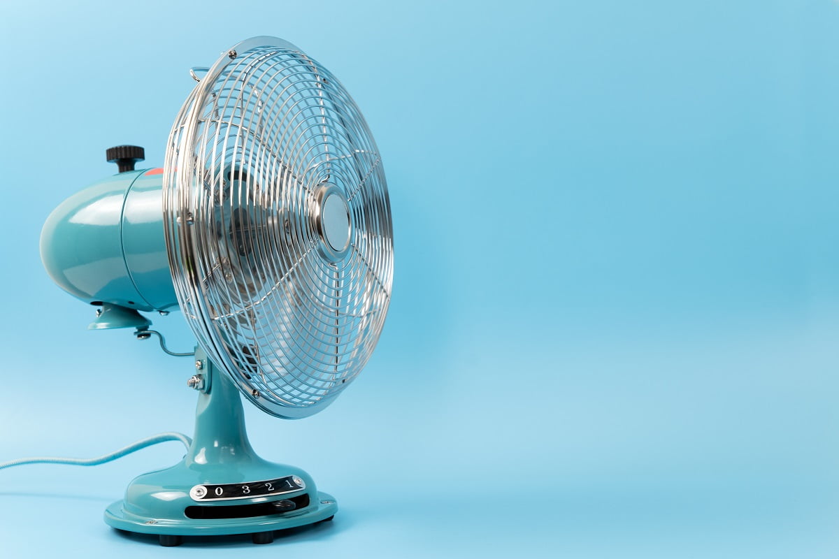 Retro vintage tabletop fan isolated on a blue background. What Fan Blows The Coldest Air.