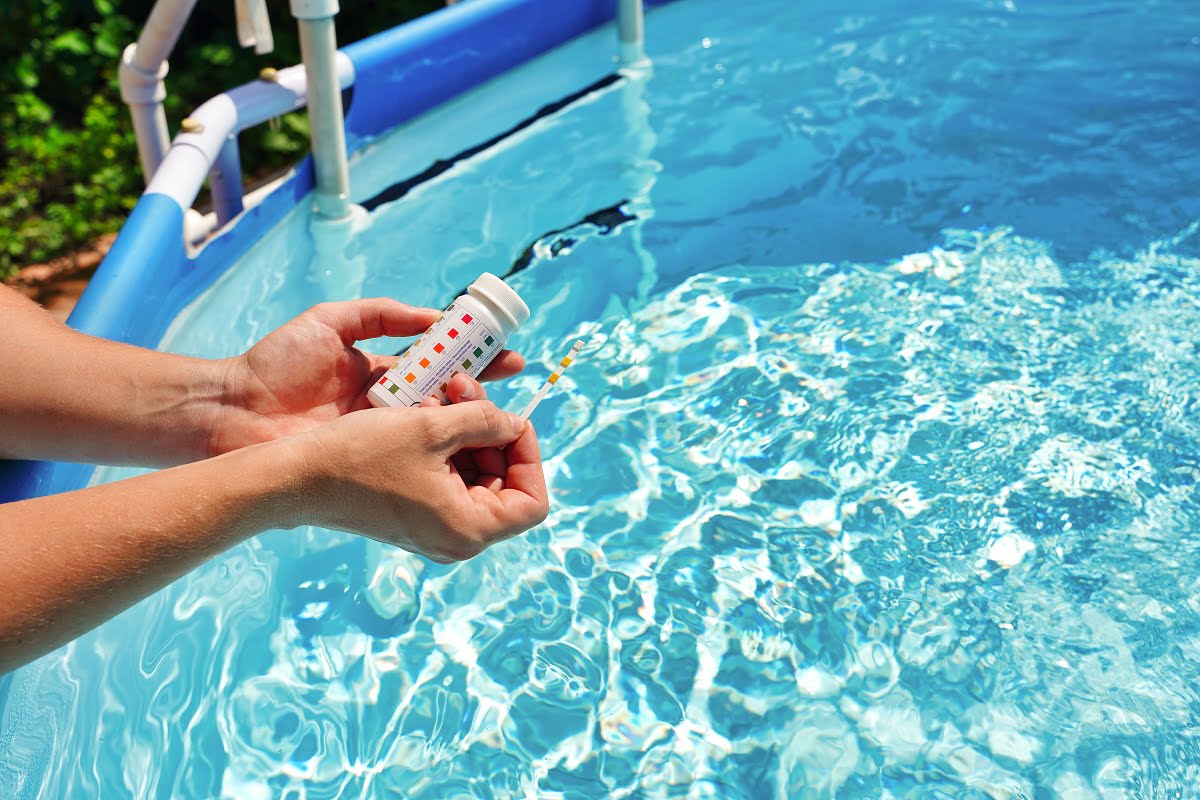 Checking the water quality of a pool with the help of a test strip with PH value, chlorine and algaecide. High quality photo. Are Pool Testing Strips Any Good.