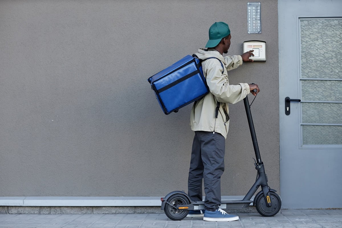 Food delivery worker ringing doorbell while riding electric scooter. Wireless Doorbell Keep Ringing Final Words.