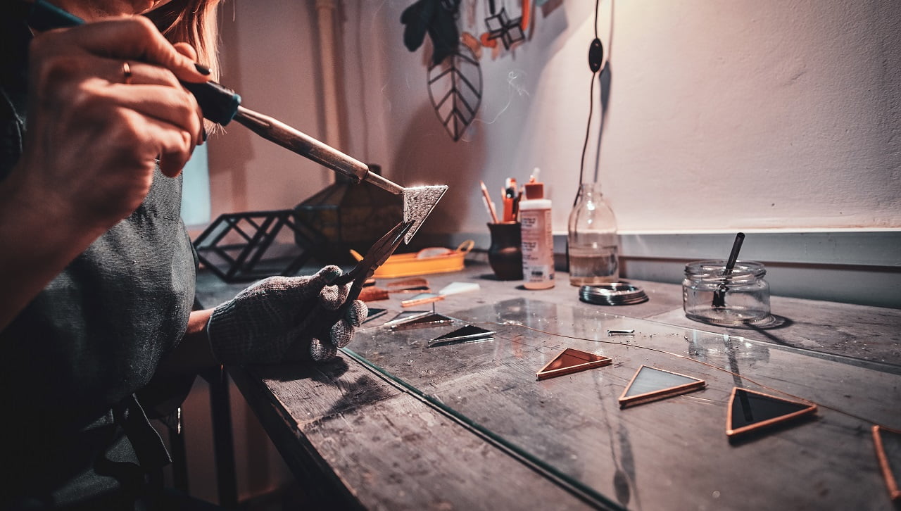 Process of working with iron solder, making new part of lamp. Closeup photo shoot. Soldering.