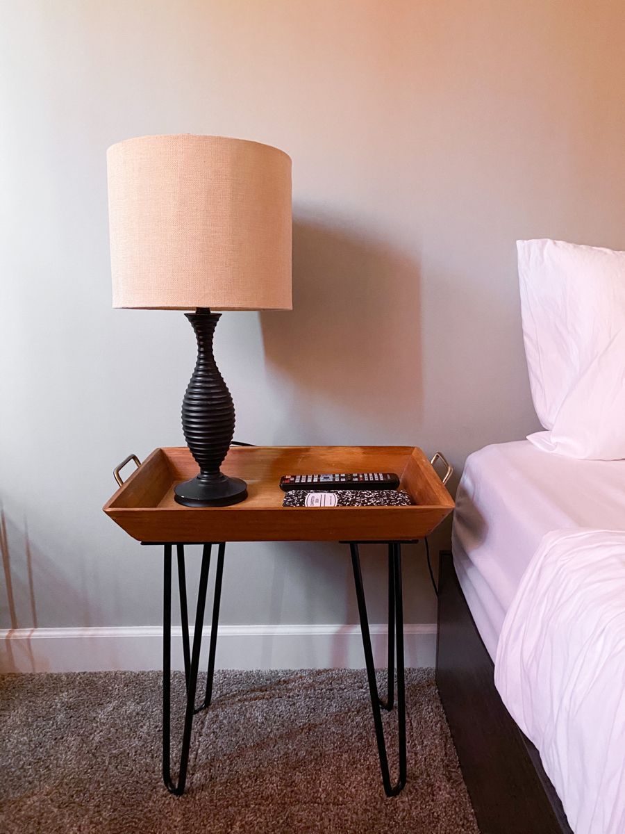 Tray top nightstand with hairpin legs beside a bed